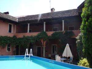 a house with a swimming pool in front of a building at B&B Locanda Tempi Lontani Adults Only in Orta San Giulio