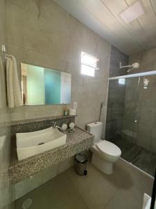 a bathroom with a sink and a toilet and a mirror at Pousada do Nativo in Fernando de Noronha
