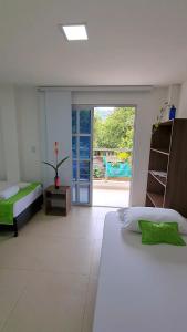 1 dormitorio con 2 camas y puerta corredera de cristal en Ecohotel Linda Judith, en Bahía Solano