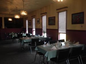 un comedor con mesas, sillas y luces en Pleasant Valley Motel Houston, en Houston