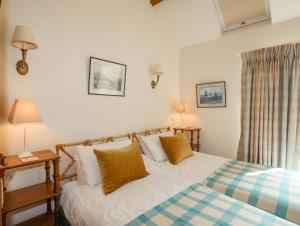 a bedroom with a bed and two lamps and a window at Llo Bach Bach in Abergele