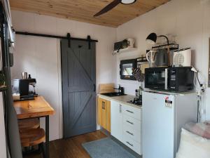 a kitchen with a white refrigerator and a blue door at Tiny Home - Bluebird in Hartley