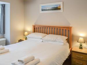 a bedroom with a large white bed with two towels on it at Sea Shells in Sutton on Sea