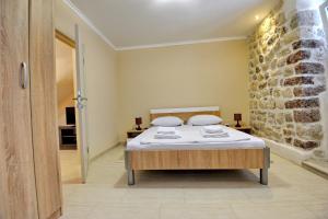 a bedroom with a bed and a stone wall at Apartments Ave R in Kotor