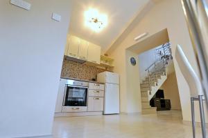a kitchen with white appliances and a staircase at Apartments Ave R in Kotor