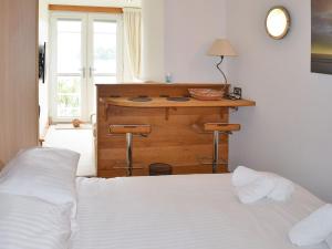 a bedroom with a bed and a desk with a window at Salcombe 16 in Salcombe