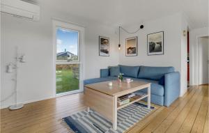 a living room with a blue couch and a table at Amazing Home In Allinge With Wifi in Allinge