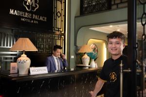 a man standing in front of a counter in a hotel at Madelise Palace Hotel & Spa in Hanoi