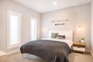a bedroom with a bed and a sign on the wall at Family Tides Beach House in Rosebud
