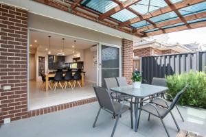 a patio with a table and chairs and a dining room at Family Tides Beach House in Rosebud