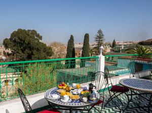 a table with a plate of food on a balcony at Riad Anis Fes in Fez