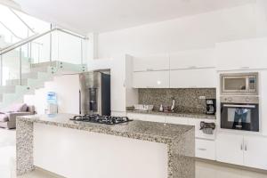 uma cozinha com armários brancos e uma bancada em Casa finca con piscina em Santa Marta