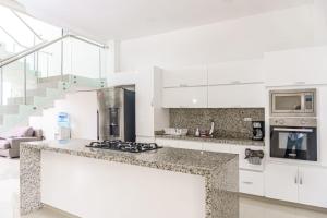 cocina con armarios blancos y encimera en Casa finca con piscina en Santa Marta