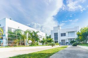 um edifício branco com palmeiras em frente em Casa finca con piscina em Santa Marta