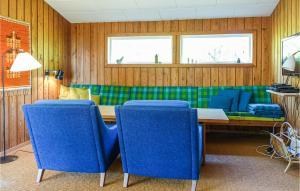 Gorgeous Home In Nex With Kitchen في Vester Sømarken: غرفة طعام مع طاولة وكراسي زرقاء