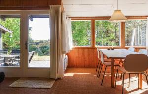 uma sala de jantar com uma mesa e cadeiras e uma janela em Gorgeous Home In Nex With Kitchen em Vester Sømarken