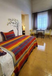 Un dormitorio con una cama con una manta de colores. en Departamento Rustico 1, en Tarija
