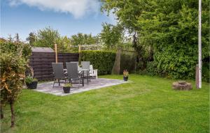 a patio with chairs and a table in a yard at Lovely Home In Juelsminde With Kitchen in Sønderby
