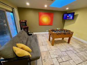 a living room with a foosball table and a tv at Newer Ranch with Pool and Hot Tub near the Strip and Freemont street. in Las Vegas