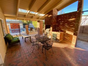 a patio with a table and chairs and a fireplace at Newer Ranch with Pool and Hot Tub near the Strip and Freemont street. in Las Vegas