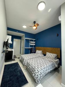 a bedroom with a bed and a blue wall at jugi suite @ Horizon Sepang KLIA in Sepang