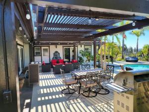 een patio met een tafel en stoelen en een zwembad bij High on the Hill Serene View Home on Avocado Grove in Fallbrook