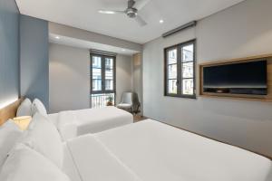 Una sala de estar con muebles blancos y un televisor de pantalla plana. en Laputa Hotel Phú Quốc, en Phu Quoc