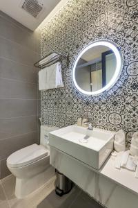 Un baño con lavabo, inodoro y espejo. en Laputa Hotel Phú Quốc, en Phu Quoc