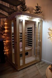 uma sauna de madeira num quarto com luzes em Les alouettes em Caudry