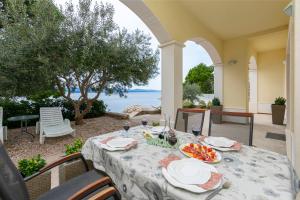 einen Tisch mit einem Teller Essen auf einer Terrasse in der Unterkunft Apartments Beach Dream in Mimice