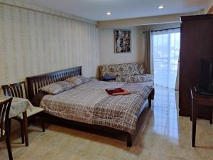 a bedroom with a bed and a couch and a table at Jomtien Beach Condominium S1 by Olga in Jomtien Beach +37 photos