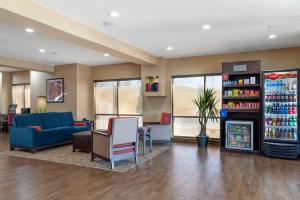 a waiting room with a blue couch and a refrigerator at Comfort Suites Locust Grove Atlanta South in Locust Grove