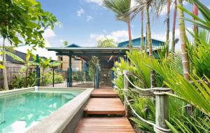 Machans BeachにあるVilla Oshea - Balinese Beachfront Escape with Poolのスイミングプールとウッドデッキ付きの家
