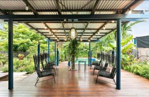 a patio with chairs and a table on a deck at Villa Oshea - Balinese Beachfront Escape with Pool in Machans Beach