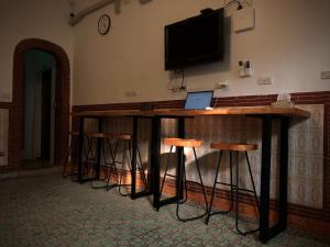 a bar with stools and a television on a wall at 不倒翁輕旅可用優惠價預約機場碼頭接送 in Hsi-kuo-shan +23 photos