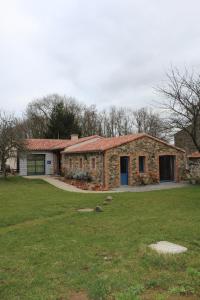 a stone house with a grass field in front of it at La Maison Des Landes in Mouzillon +20 photos