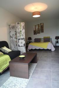 a living room with two beds and a table at La Maison Des Landes in Mouzillon