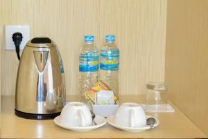 a tea kettle and two bottles of water on a shelf at KAWANA HOTEL in Kampungdurian