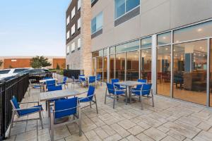 een patio met tafels en stoelen voor een gebouw bij Holiday Inn Express & Suites Austin North - Pflugerville, an IHG Hotel in Pflugerville