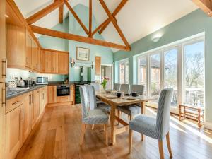 a kitchen with wooden cabinets and a wooden table and chairs at The Fishing Lodge in Amesbury