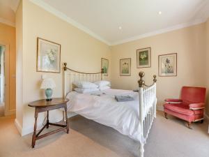 a bedroom with a bed and a table and a chair at The Fishing Lodge in Amesbury