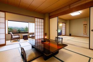 een woonkamer met een tafel en stoelen en een kamer met ramen bij Nikko Hoshino Yado in Nikko