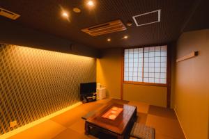 a living room with a couch and a tv at Guest House Takiyoshi in Hongu