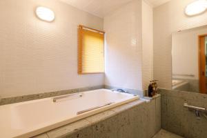 a bath tub in a bathroom with a window and a bath tub at Nikko Hoshino Yado in Nikko