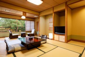a living room with a table and a tv at Nikko Hoshino Yado in Nikko