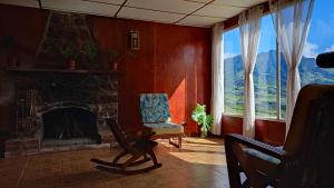 sala de estar con silla y chimenea en Las Nubes Hostal, 