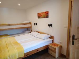 a bedroom with a bunk bed with white sheets at Apartmaji Hodak in Bohinj