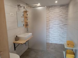 y baño blanco con lavabo y ducha. en Apartmaji Hodak, en Bohinj