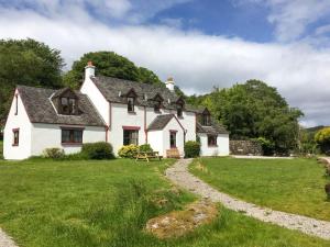 a white house with a grassy yard at Innish Beag - Uk38782 in Clachan
