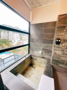 a bathroom with a shower with a bench and a window at 天天泡湯 in Yilan City